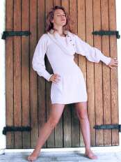 Junge Frau mit kurzem Alpaka Kleid Donna in Naturweiß uni, mit weitem Schalkragen und langen Ärmeln.
