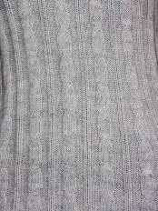 Nahaufnahme der Zopfmuster-Strickarbeit, 100 % Alpaka, hellgrau: handgefertigte Verarbeitung des Pullovers Modell Zora.