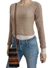 Vor weißem Hintergrund, Frau mit kurzem beigem Pullover aus Baby Alpaka und Pima-Baumwolle, Modell Fiona, Jeans und peruanischer Ethno-Handytasche.